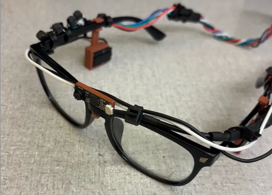 The final wearable product mounted on black glasses. Buttons rest on the right side of the glasses, and the camera above the bridge.