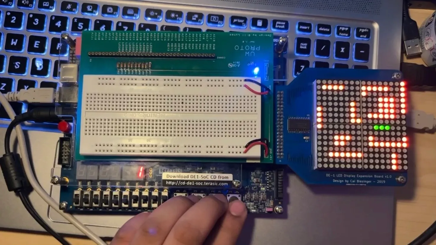 Snake running on a LED matrix attached to an FPGA controlled with buttons on the bottom.